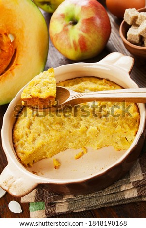 Pumpkin casserole with apple and semolina on the wooden table