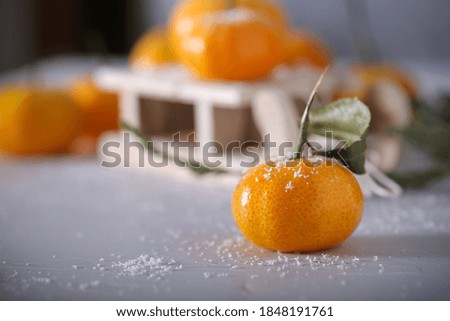 tangerines small in the snow on a decorative sled	
