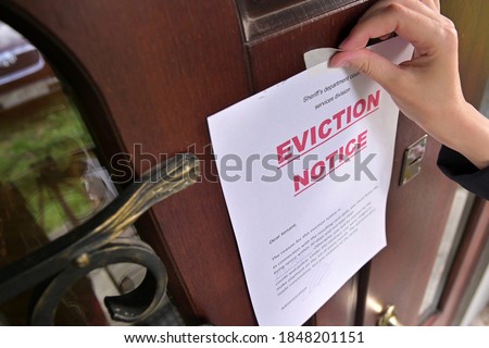Civil servant sticks a notice of eviction of the tenant, close up Royalty-Free Stock Photo #1848201151