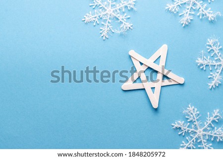 Wooden Handmade Christmas star and large snowflakes on red background