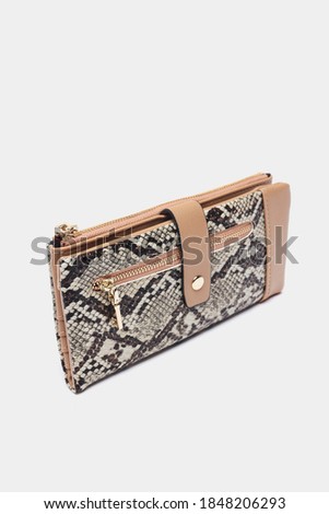 Women's wallet with snakeskin texture on gray background
