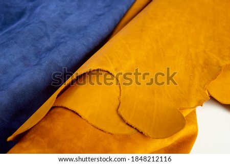defocused rolls of natural brown and navy leather. Concept of materials for leather craft