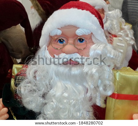 Toy Santa Claus with glasses and a white beard in the New Year's assortment in the store. Christmas background.