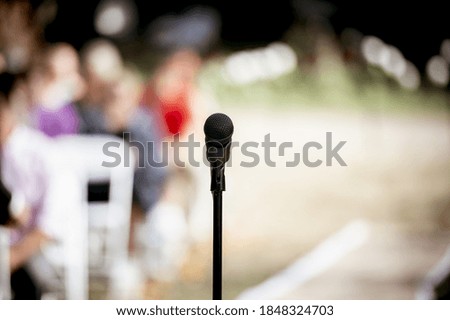 A selective focus shot of a microphone on the stage outdoors