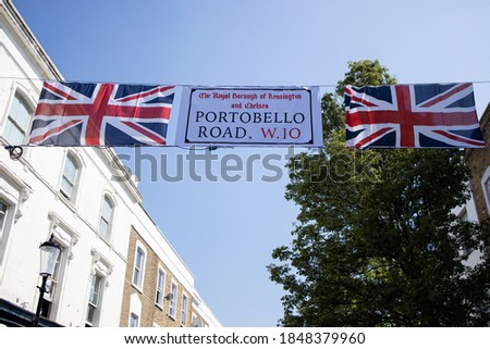 Flag of United Kingdom and Portobello Road sign hanging over the street