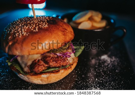 A selective focus shot of a tasty hamburger with french fries in a bowl