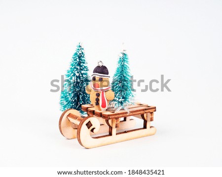 Toy in the shape of a Christmas tree, gingerbread cookie. toy snowman on a sled.