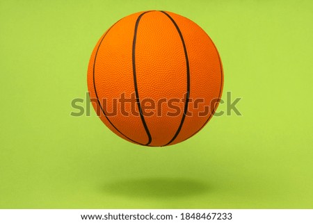 Orange basketball ball isolated on green background