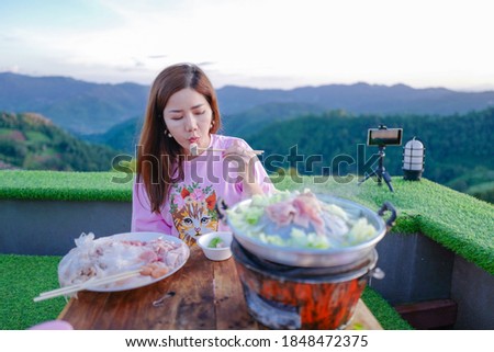 Asian woman is eating barbecue Grill Pork on the mountain. Thai barbecue Grill Pork on hot pan buffet, Moo-gata Pork pan It`s traditional Thai style BBQ, barbecue buffet pig pan. Royalty-Free Stock Photo #1848472375