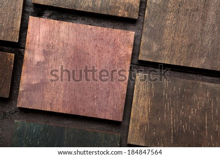Small colored pieces of wood on a dark wooden table, with space for your text
