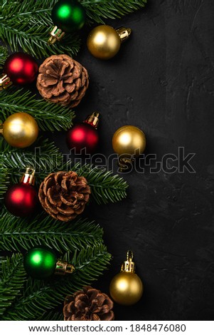 Christmas composition. Colorful ornament, pine cones and fir needles decorations on dark background. Top view copy space