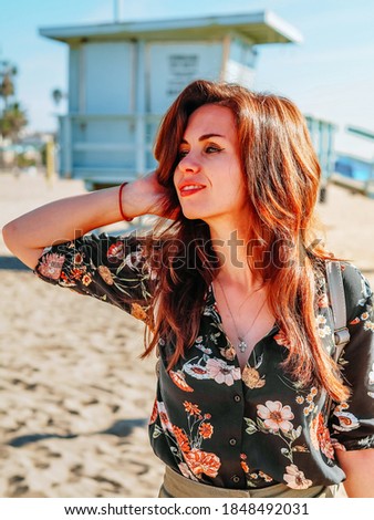 Beautiful young woman walks on beache of Los Angeles on a Sunny day