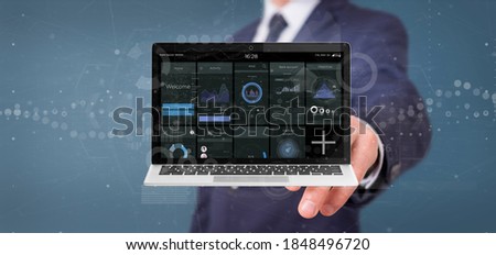 View of Businessman holding Laptop with business user interface data on the screen isolated on a background