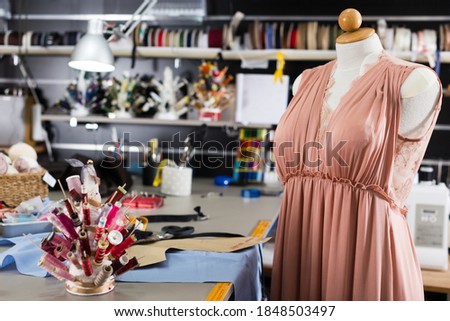 Photo of mannequin on the modern workplace with special equipment in the sewing workshop.