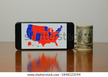 A picture of  US election map on smart phone and fake dollar insight. People are waiting the outcome of US President 2020 Election.