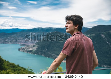 man use phone in a beautiful view of Lugano and it's lake from the Belvedere