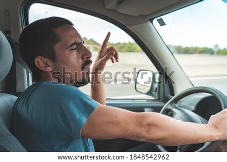 Happy young man driving a car dancing and singing. Fun trip, transportation and vehicle concept. Royalty-Free Stock Photo #1848542962