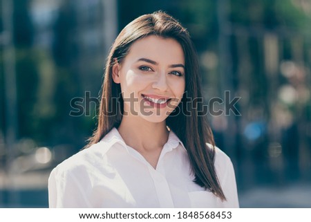 Photo of confident adorable pretty young woman wear white formal shirt smiling outdoors