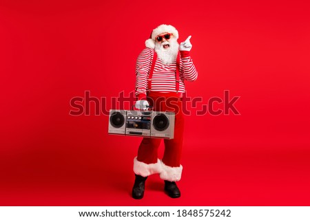 Full length body size view of his he nice handsome cheerful cheery comic childish Santa father having fun celebratory festive listening stereo isolated bright vivid shine vibrant red color background