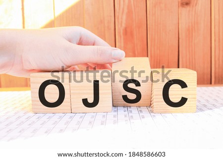 word OJSC on wooden blocks, white background, business concept. business and Finance