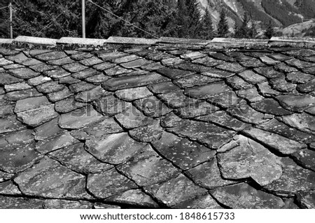 Detail of a roof of a house with slate tiles in the Aosta Valley
