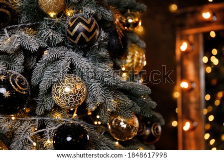 Beautiful festive Christmas tree is in the room decorated with Christmas toys balls
