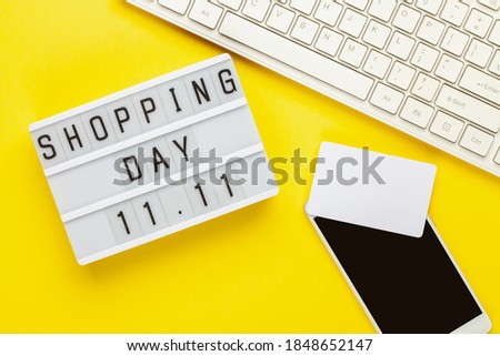 Shopping Day 11.11 text on lightbox on a yellow paper background . Design for promotion of winter end of year sale. Top view. Flat lay
