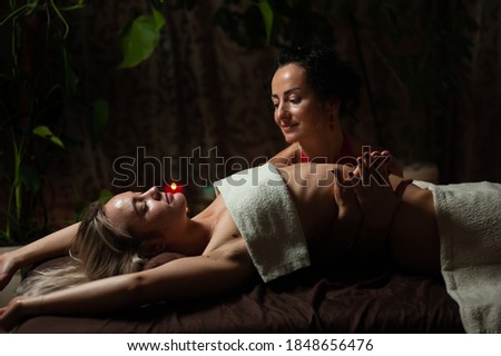 Young woman enjoys massage in a luxury spa resort. low key photo