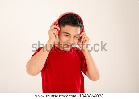 Asian guy in red enjoy music