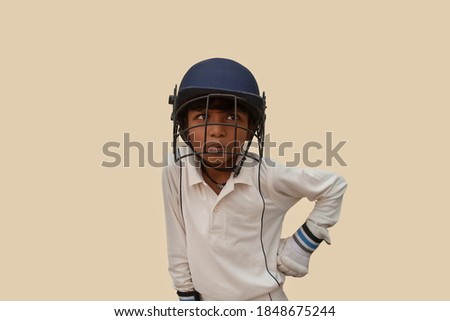 A boy in cricket uniform  standing