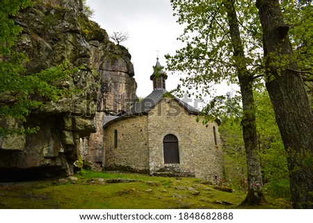 A small church built on the side of a mountain in the middle of nature in France. landscape picture taken of a small castle 