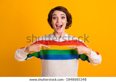Photo of crazy young girl open mouth direct fingers her sweater wear striped pullover isolated yellow color background