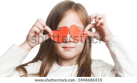 Little preschool girl and paper hearts. Isolated little girl covers her eyes with paper hearts on white background. close up portrait. isolated