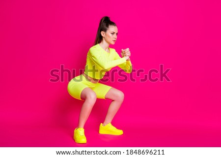 Full body profile side photo of intense athletic girl doing sit-ups isolated on pink bright color background