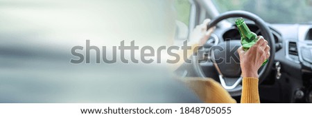 Woman drinking alcohol while driving; panoramic banner