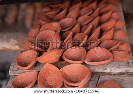 Traditional diya made of clay and mud placed in sunlight at Diya factory in Rural India. Diya used to lit home on the occasion of Diwali and other festivals.