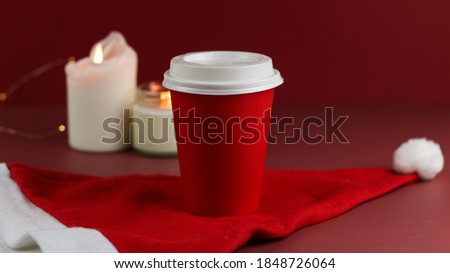 take away red coffee cup to go on red background. Christmas atmosphere, decoration, sales, spend time with friends. Concept holiday, new year, celebration card