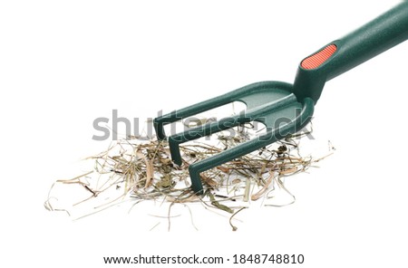 Rake and hay pile, dry grass isolated on white background
