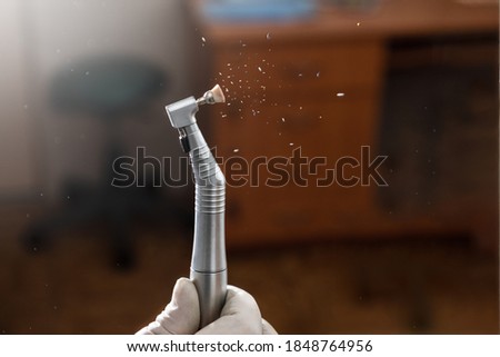 Dental highspeed handpiece and polishing brush in action with dark background Royalty-Free Stock Photo #1848764956
