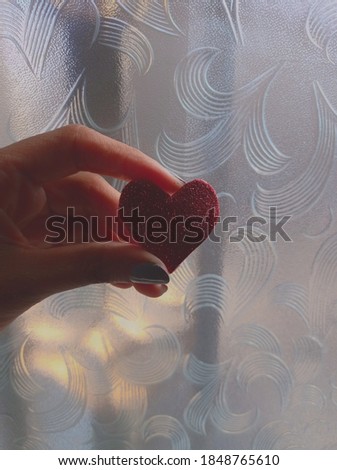 Picture of hand hold red heart made of glitter foam sheet. Photo of texture and background photography.