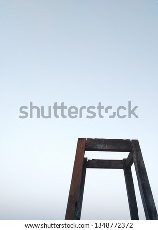 old wooden stool like structure with sky blue/white background of clear sky