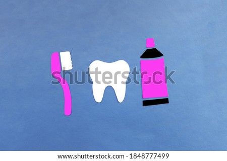 Tooth brush for cleaning teeth, tube of toothpaste on a blue background. Oral hygiene, dentistry.