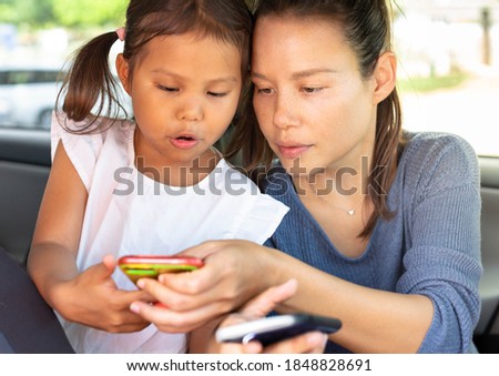 People and electronics, mother and daughter on the phone. Technology.