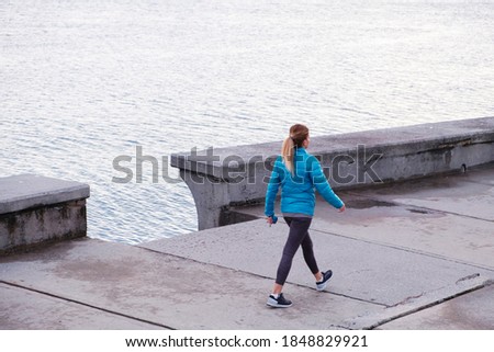 blonde fit woman doing morning sports walking by the seaside Royalty-Free Stock Photo #1848829921