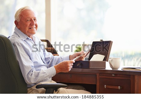 Senior Man Putting Letter Into Keepsake Box