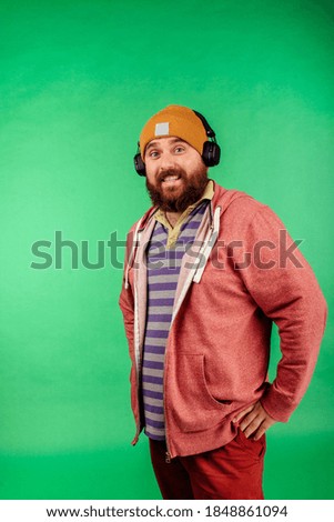Cheerful handsome guy listening to music with headphones