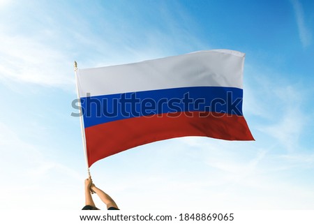 Russia flag holding hands in the air. Blue Sky Flag and Freedom