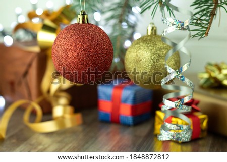 Christmas and New Year gifts in festive packaging under the tree. Make gifts under the tree, on the table, on a wooden background with space for text