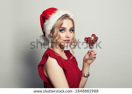 Pretty woman Santa holding glass of wine with Xmas decoration on white background