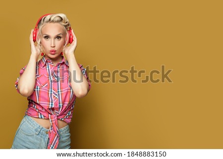 Perfect pinup woman with headphones enjoying music on bright yellow background